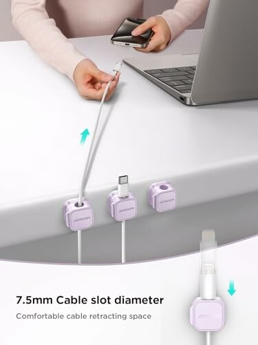 Person organizing cables with desk cable holders.