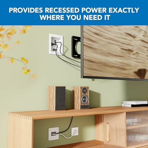 Recessed power outlet behind wall-mounted TV and speakers.